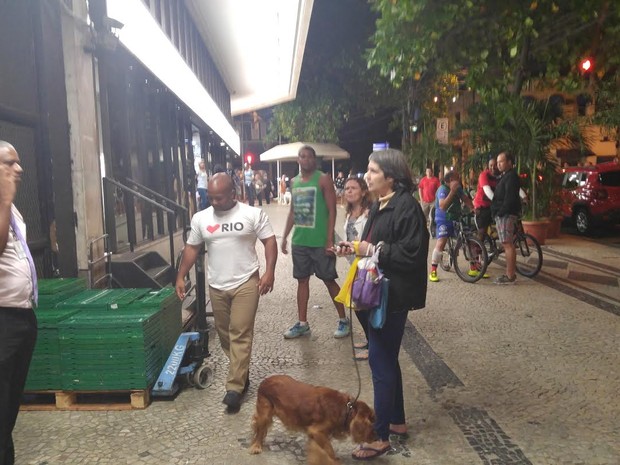 Maria Francisca (de pé, com o cão), foi presa suspeita de racismo contra Paulo (no celular) (Foto: Daniel Targueta/TV Globo)