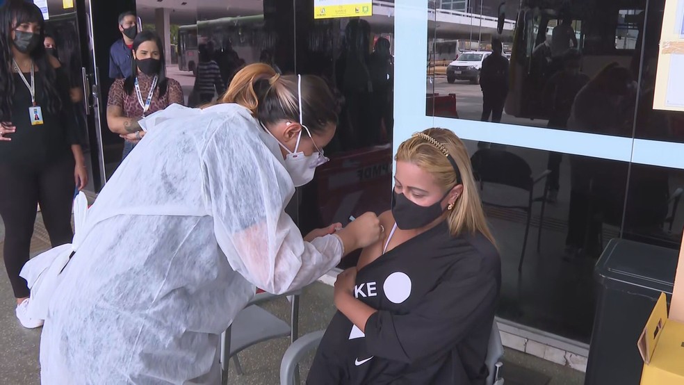 Mulher recebe dose da vacina contra Covid-19, no DF — Foto: TV Globo/Reprodução