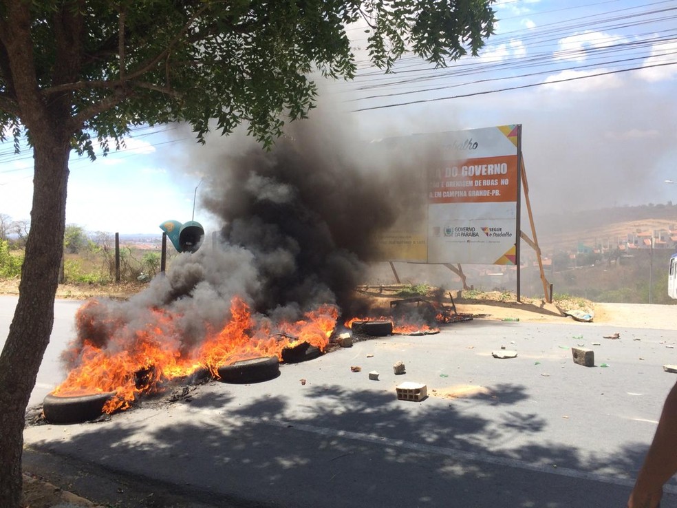Após a morte da vítima, pneus foram queimados e colocados no meio da rua, impedindo o tráfego de veículos no local — Foto: Érica Ribeiro/G1