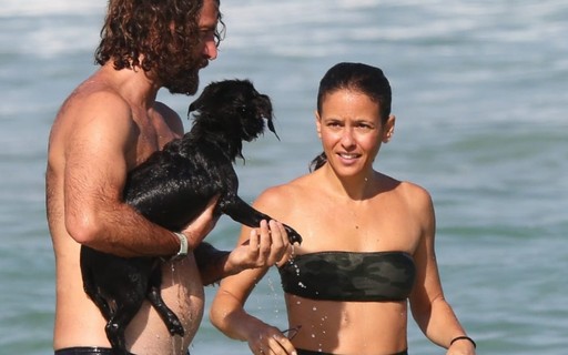 Fernanda de Freitas toma banho de mar com marido e cachorro
