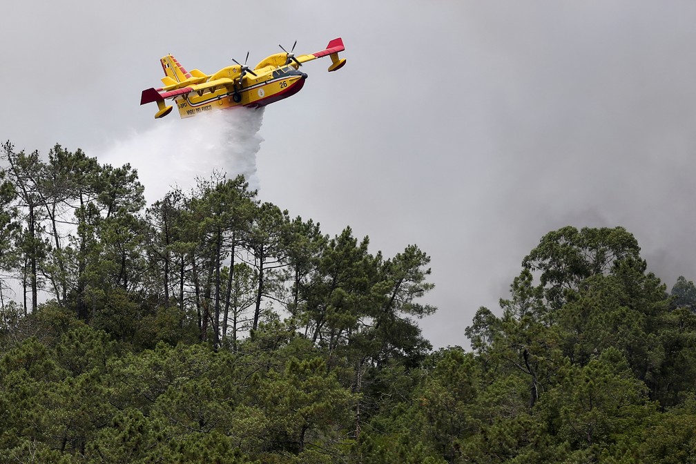 Um avião trabalha para conter um incêndio florestal em Leiria, Portugal, em 14 de julho de 2022. — Foto: REUTERS/Rodrigo Antunes