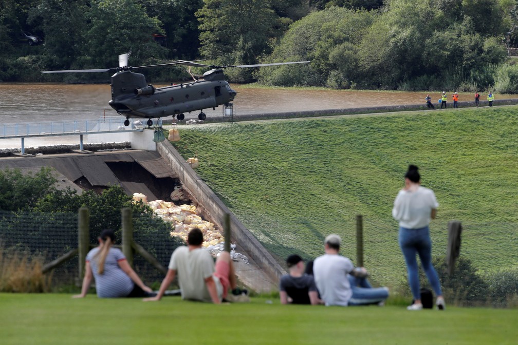 Pessoas observam trabalho de militares para evitar rompimento de represa em Whaley Bridge, na Inglaterra, nesta sexta-feira (2)   â Foto: Phil Noble/ Reuters 