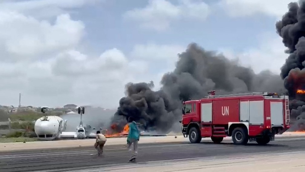 Bombeiros controlam incêndio em avião que virou durante o pouso na Somália — Foto: Reprodução via Reuters