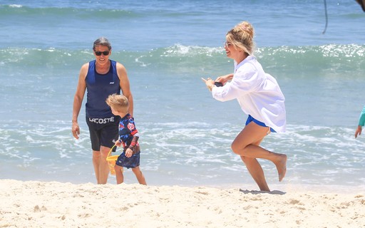 De camisão, Karina Bacchi se diverte com filho e marido em praia