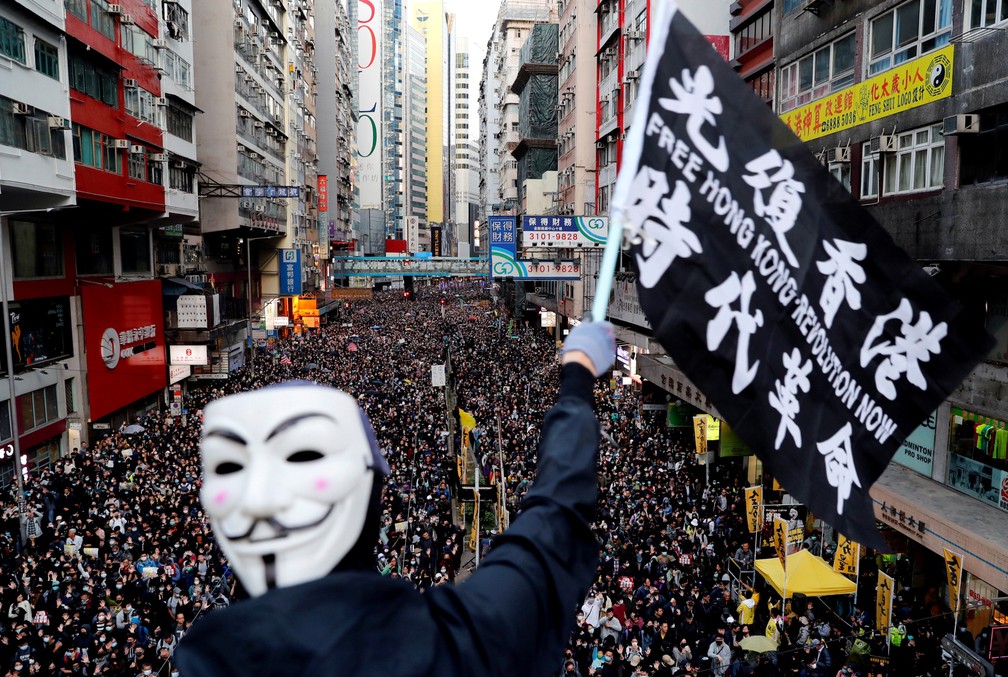 8 de dezembro - Um manifestante com uma máscara de Guy Fawkes segura uma bandeira durante a marcha do Dia dos Direitos Humanos em Hong Kong — Foto: Danish Siddiqui/Reuters