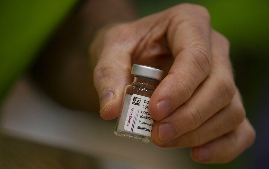 Um farmacêutico pega um frasco da vacina AstraZeneca contra covid-19 na Vaccine Village, em Antuérpia, Bélgica