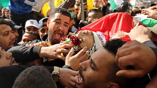 Enlutados carregam o corpo do jovem palestino Yusef Muhaisen, morto em ataque israelense em meio a confrontos, durante seu funeral na cidade de Al-Ram, na Cisjordânia. — Foto: AHMAD GHARABLI / AFP