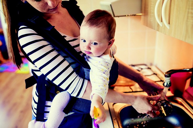 Mãe com bebê realizando tarefas domésticas (Foto: Thinkstock)