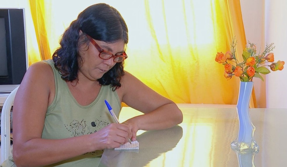 Mulher de Donizete já chegou a fazer mais de 100 papelzinhos por dia para ele entregar nos bairros de Bauru (Foto: Fernando Savioli / TV TEM )