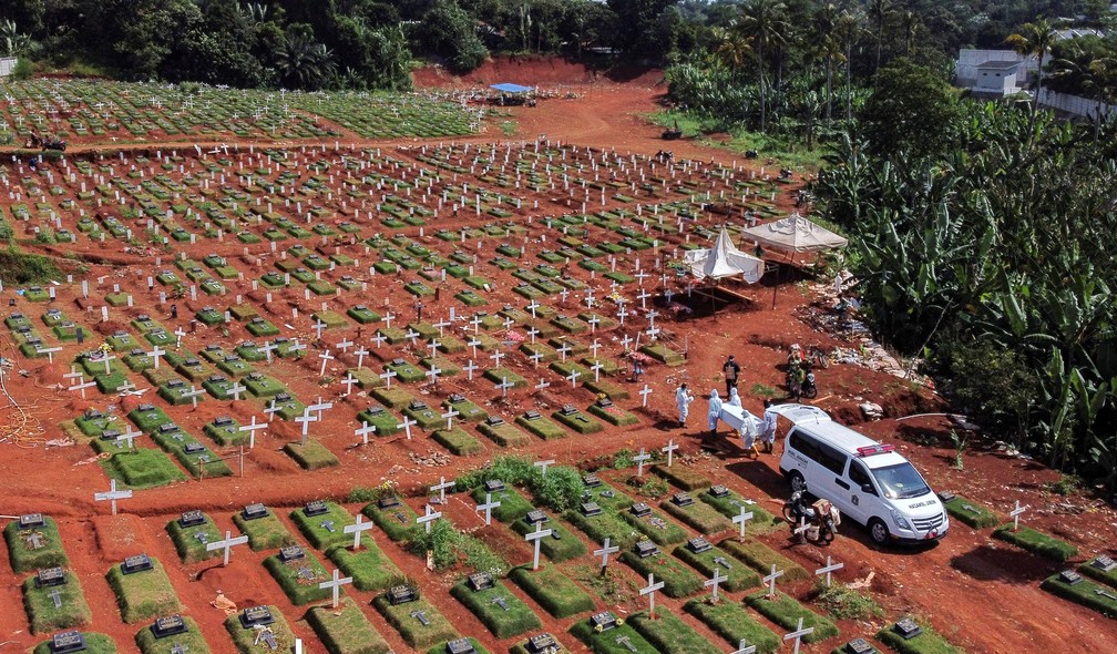 Vista aérea de um cemitério em Jacarta, na Indonésia, mostra coveiros com roupas de proteção carregar um caixão com uma vítima de Covid durante a pandemia do novo coronavírus — Foto: Willy Kurniawan/Reuters