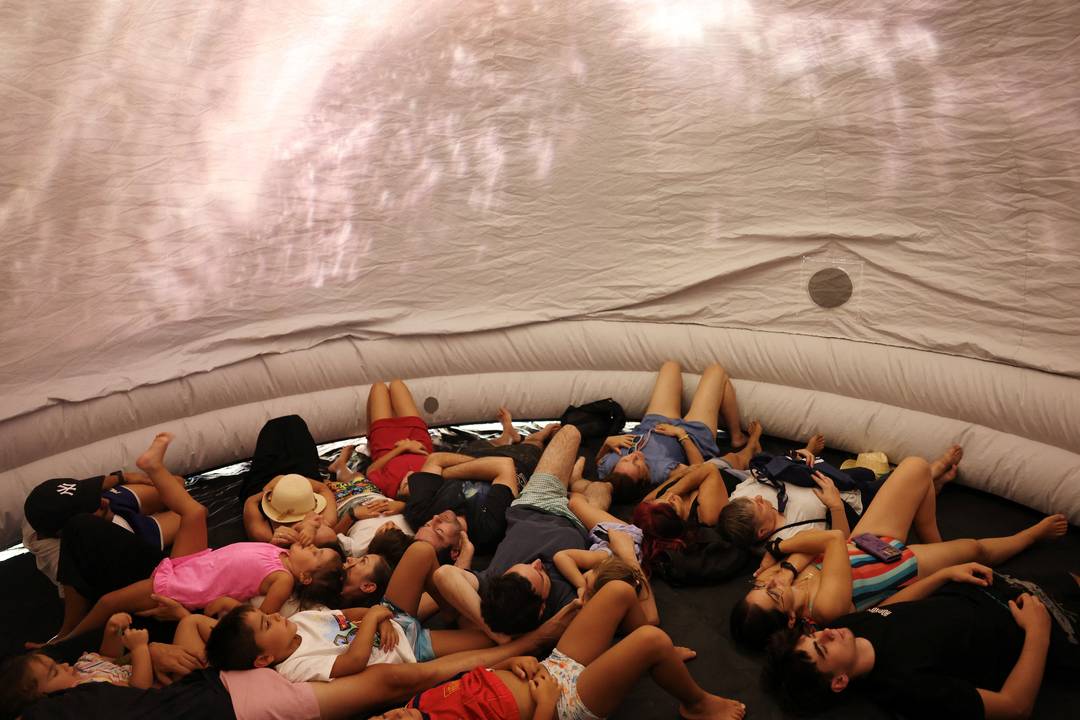 Pessoas descansam dentro de um planetário portátil durante um evento para acompanhar o eclipse solar total em Buitrago del Lozoya, na Espanha, nesta quarta-feira (12).