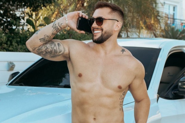 Arthur Picoli posa sem camisa em frente a carro e segurando um celular (Foto: Reprodução/Instagram)