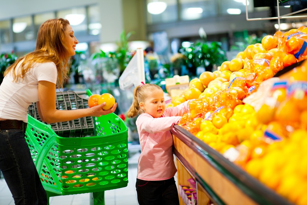 Mãe e filha escolhendo frutas no supermercado (Foto: Shutterstock)