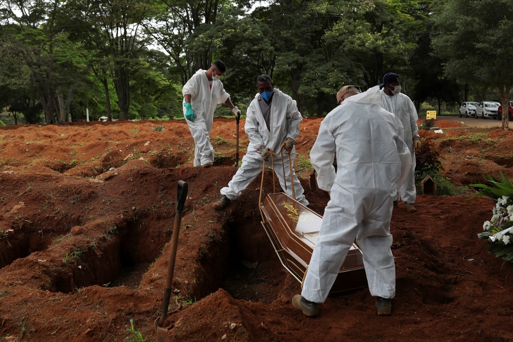 Coveiros usando roupas protetoras enterram vítima de Covid-19 no Cemitério da Vila Formosa, na Zona Leste de São Paulo, em 25 de dezembro. — Foto: Amanda Perobelli/Reuters