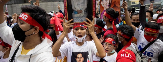 Manifestantes seguram imagens da líder civil detida Aung San Suu Kyi durante um protesto em frente à Embaixada de Mianmar, em Bangcoc. — Foto: Jack TAYLOR / AFP
