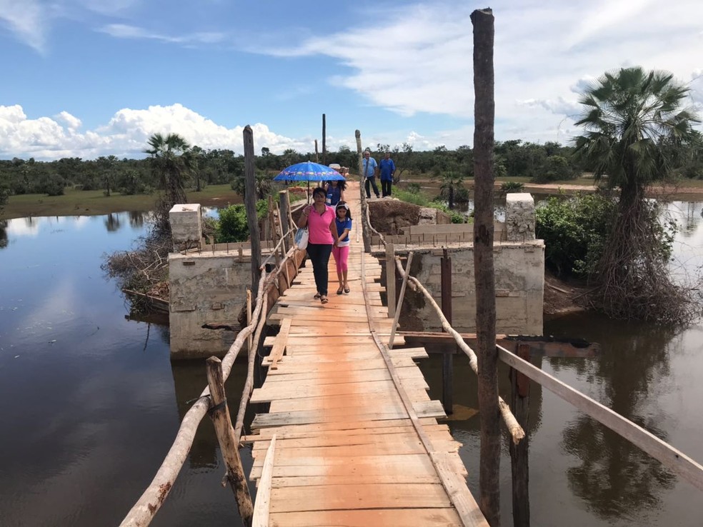 Moradores atravessam local em que deveria existir a ponte em passarela improvisada (Foto: Neyara Pinheiro/Rede Clube)