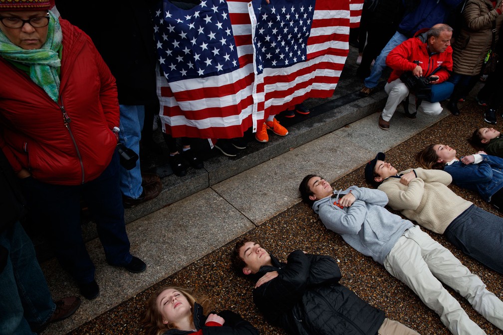 Estudantes deitam em frente à Casa Branca nesta segunda-feira (19) para pedir reforma nas leis sobre o acesso às armas nos EUA (Foto: Evan Vucci/ AP Photo)