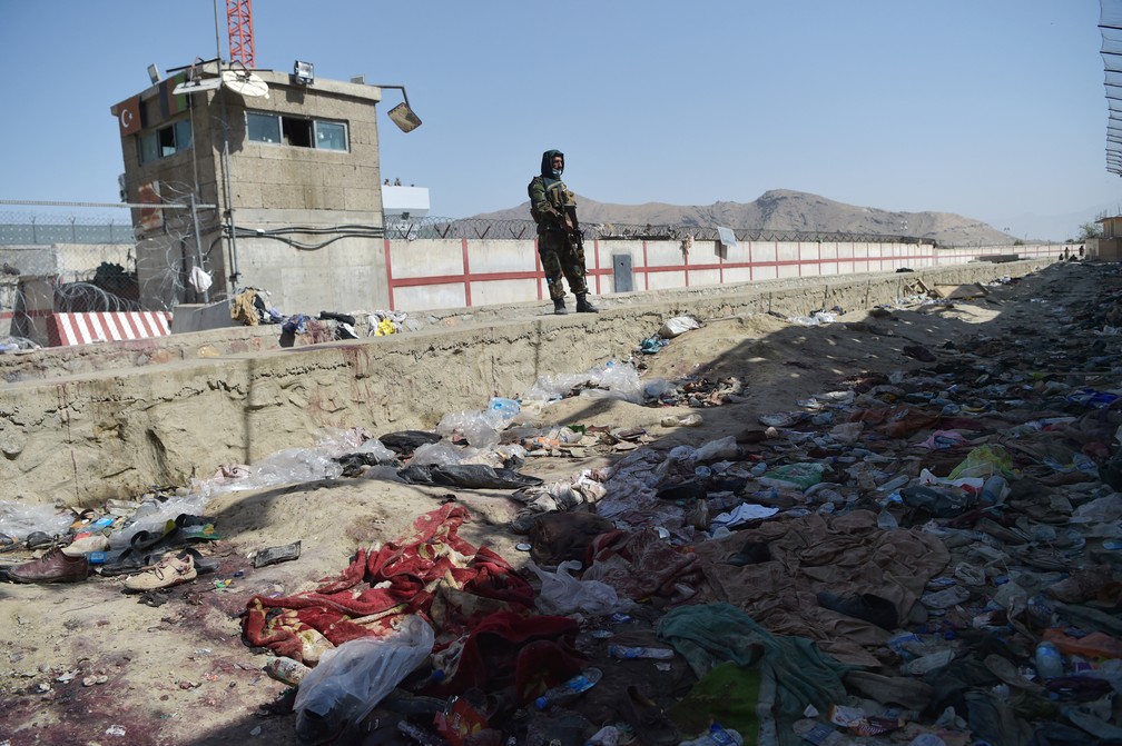 Soldado do Talibã monta guarda nesta sexta (27) no local dos dois atentados suicidas que mataram dezenas de pessoas, incluindo 13 soldados americanos, no aeroporto internacional de Cabul na quinta (26) — Foto: Wakil Kohsar/AFP