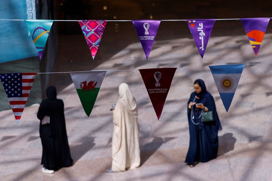 Compradoras circulam por shopping de Doha, enfeitado com bandeirinhas da Copa do Mundo do Catar