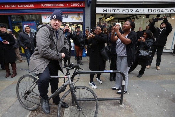 Pessoas tiram fotos do prefeito de Londres, Boris Johnson, que usa a bicicleta em vez de veículo oficial (Foto: Getty Images)