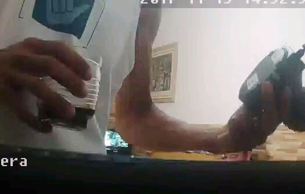 Homem observa uma das câmeras que foram roubadas de imóvel em Praia Grande, SP (Foto: Reprodução)