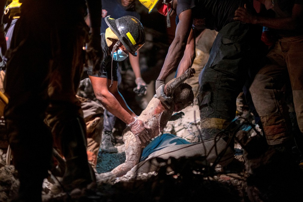 16 de agosto - IMAGEM FORTE. Bombeiros retiram corpo de menino de 3 anos de idade dos escombros de um hotel destruído após um terremoto de magnitude 7.2 na cidade de Cayes, no Haiti — Foto: Ricardo Arduengo/Reuters