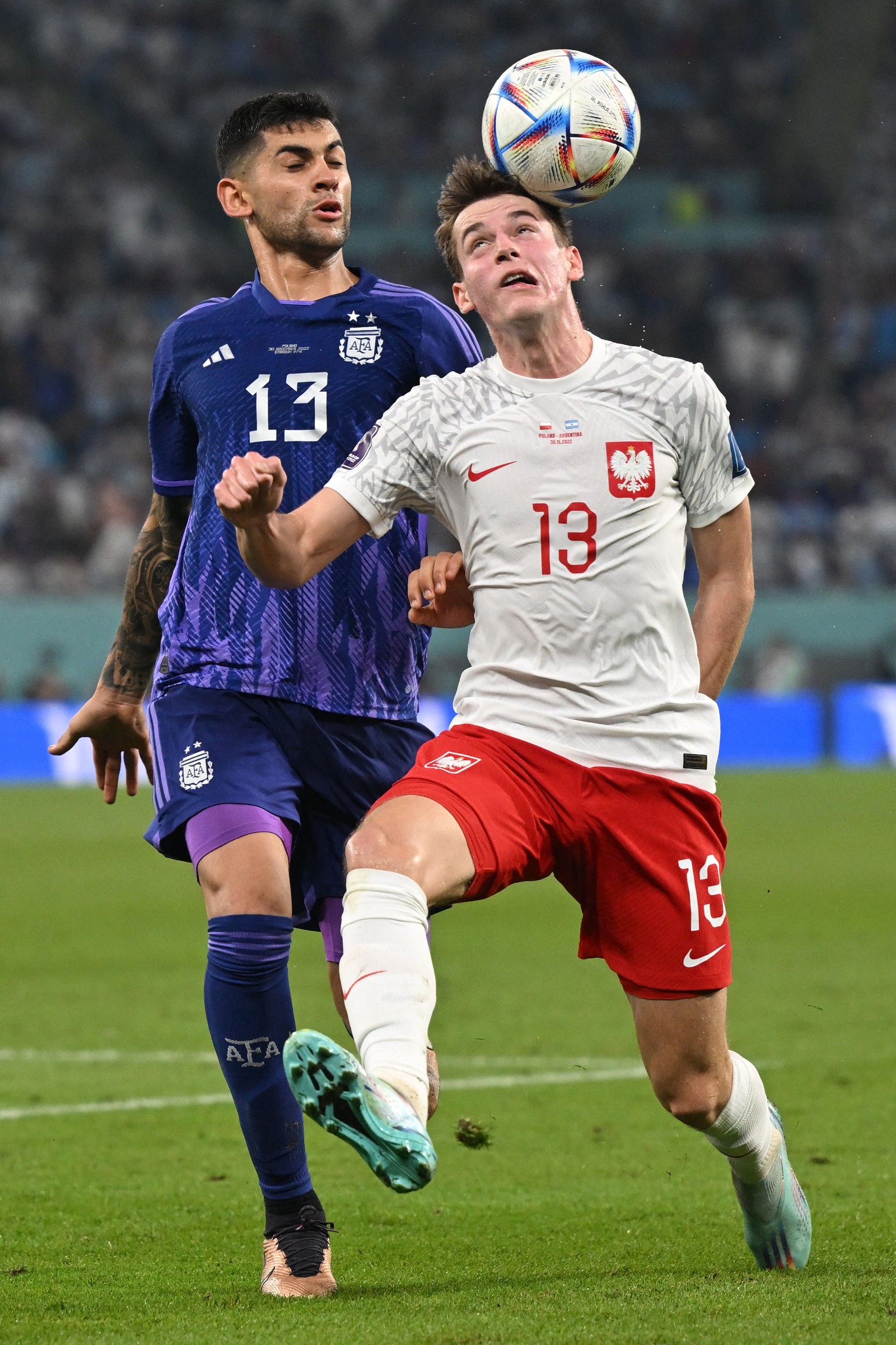 O zagueiro argentino Cristian Romero e o meia polonês Jakub Kaminski brigam pela bola — Foto: ANDREJ ISAKOVIC / AFP