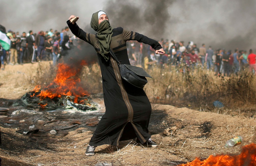 Palestina lanÃ§a pedra durante protesto na Faixa de Gaza, nesta sexta-feira (13)  (Foto: Mohammed Salem/ Reuters)