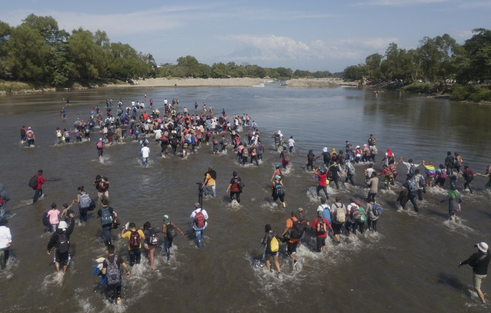 Caravana de migrantes cruza nesta segunda-feira (20) a pé o rio Suchiate, que separa o México da Guatemala, para seguir viagem rumo aos EUA — Foto: Santiago Billy/AP Photo