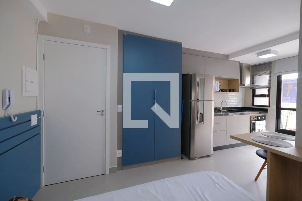 Microapartamento de 21 m². O imóvel conta com cama de casal, pequena mesa com cadeiras, cozinha equipada, banheiro e uma pequena sacada. — Foto: Reprodução/Quinto Andar