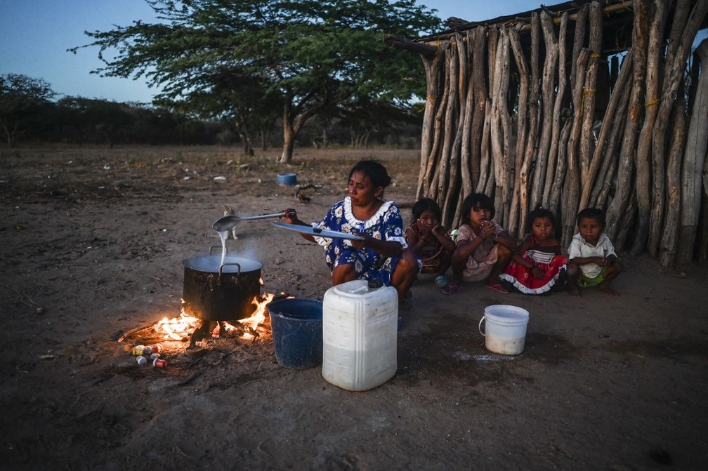 A indígena wayuu Beatriz Epieyu cozinha para seus filhos e filhas em sua casa na zona rural de Manaure, no departamento de La Guajira, Colômbia, em 21 de fevereiro de 2023. — Foto: JOAQUIN SARMIENTO / AFP
