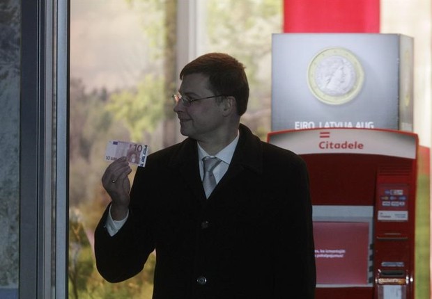 Valdis Dombrovskis, primeiro-ministro da Letônia saca a primeira nota de Euro em um caixa eletrônico do país que agora faz parte da Zona do Euro (Foto: Agência EFE)