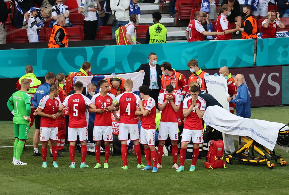 Jogadores da Dinamarca cercam atendimento a Eriksen — Foto: REUTERS/Wolfgang Rattay