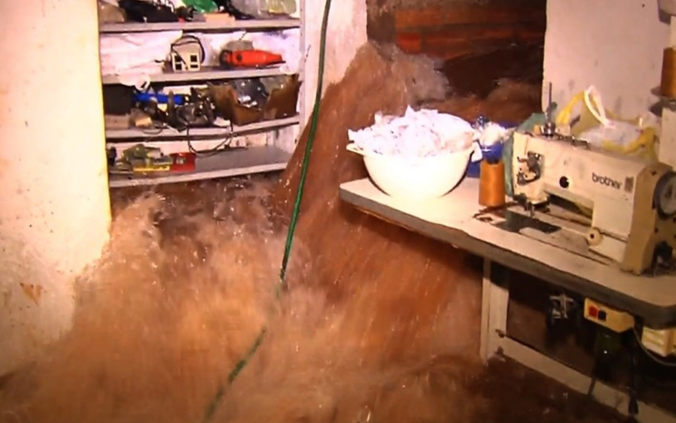 Forte enxurrada invade casa e confecção em Goiânia (Foto: TV Anhanguera/Reprodução)