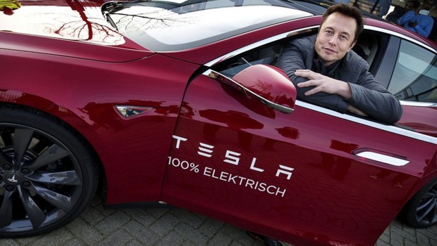 Elon Musk e um dos carros elétricos da Tesla (Foto: Jerry Lampen/AFP/Getty Images)