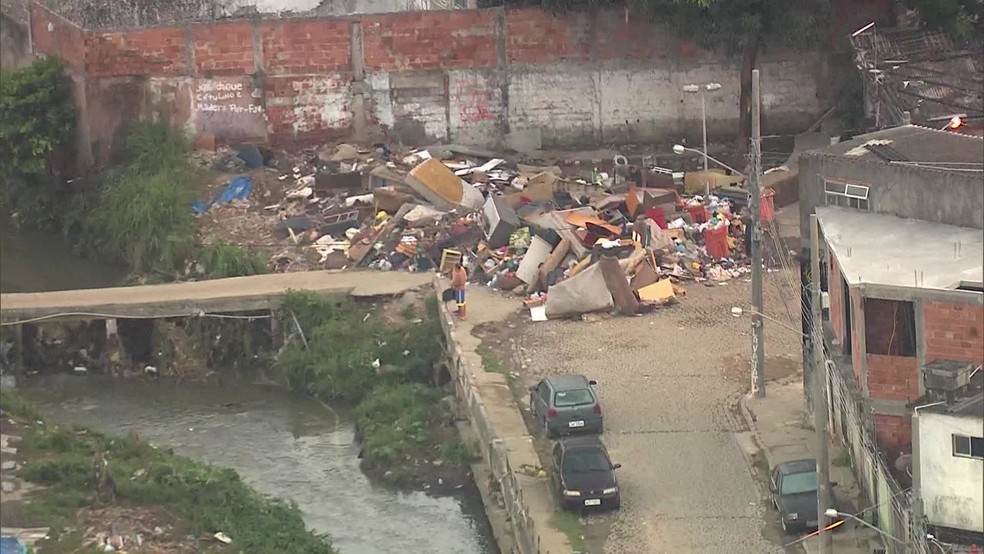 O Rio Guerenguê, em Curicica, transbordou e inutilizou objetos dos moradores da Vila Sapê (Foto: Reprodução/ TV Globo)