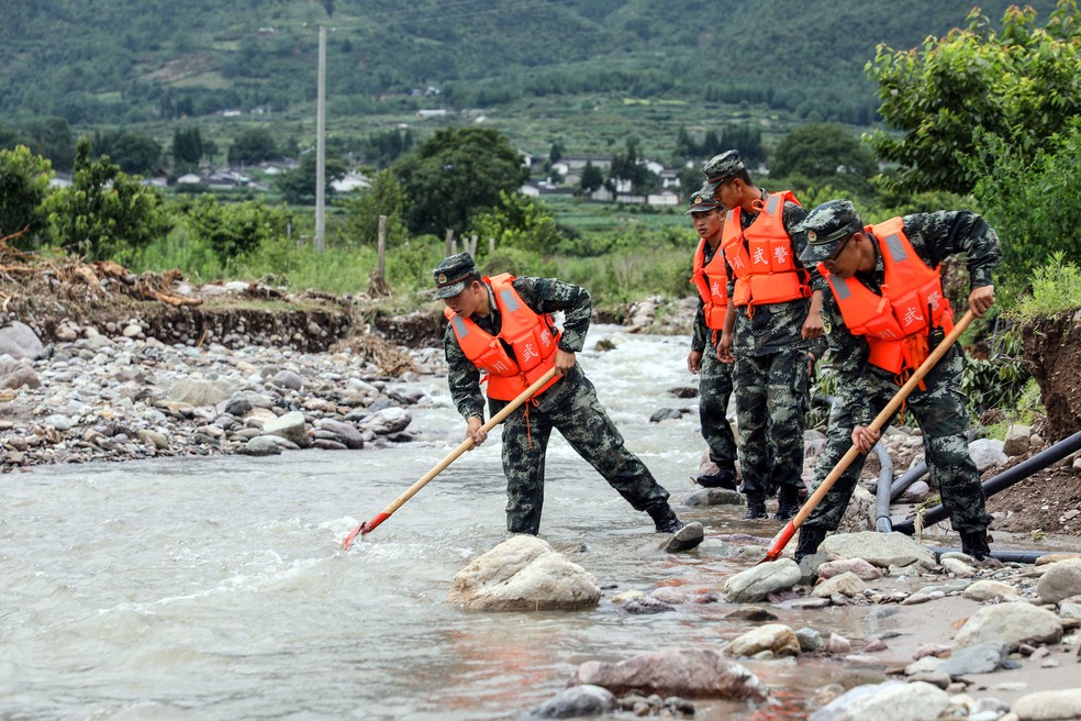 Policiais procuram pessoas desaparecidas após fortes chuvas na província de Liangshan Yi, no sudoeste da província de Sichuan, no sudoeste da China, nesta segunda-feira (29) — Foto: AFP