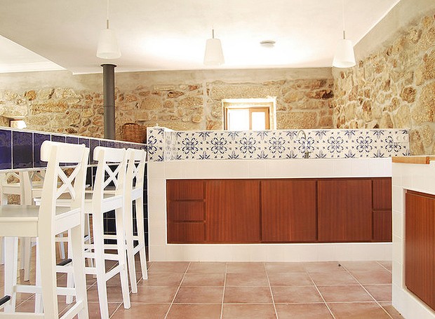 Na parte de dentro da cozinha, os armários de madeira arrematam o visual. Azulejos brancos Cinca, linha pombalino, 15 x 15, modelo branco (bancada da cuba e cooktop) (Foto: Divulgação)