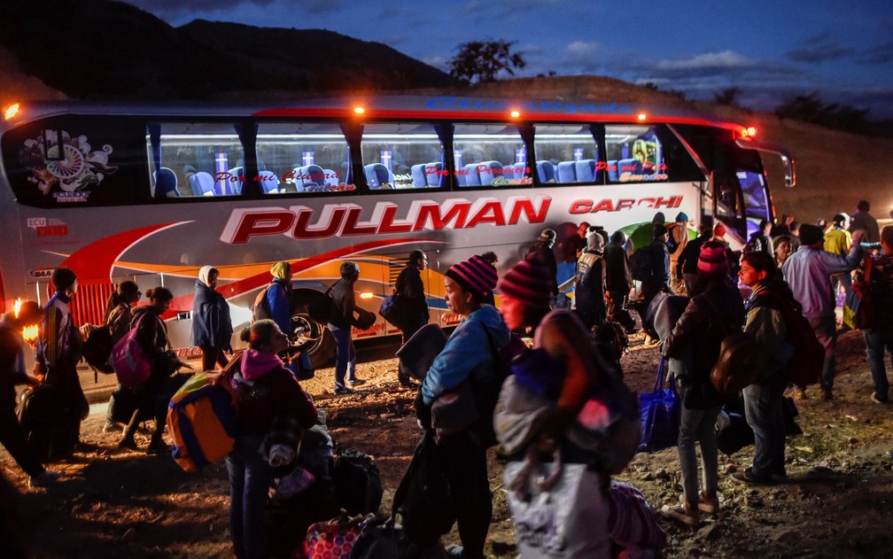 Migrantes venezuelanos embarcam em ônibus para a fronteira entre Equador e Peru, em foto de 22 de agosto — Foto: Luis Robayo/AFP