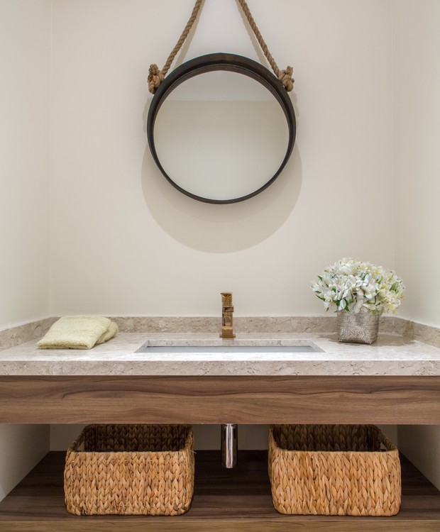 O lavabo combina piso de taco, bancada de travertino e suportes de madeira, combinação clean e elegante (Foto: André Nazareth/Divulgação)