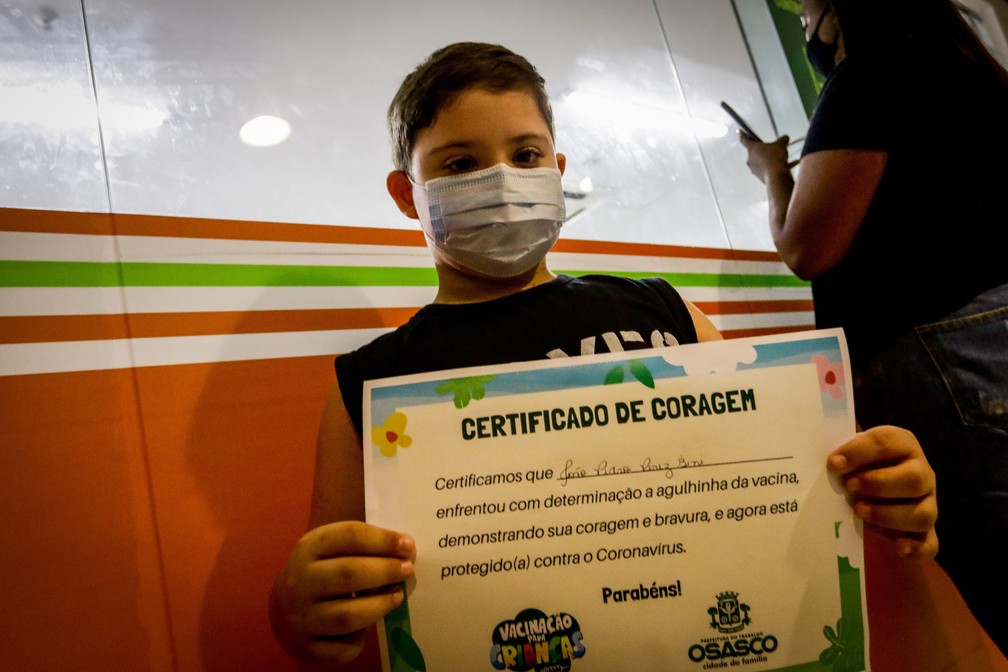 Criança recebe "certificado de coragem" após vacinação contra a Covid em shopping de Osasco, na Grande SP, neste domingo (16).  — Foto: MAURICIO/FOTOARENA/FOTOARENA/ESTADÃO CONTEÚDO