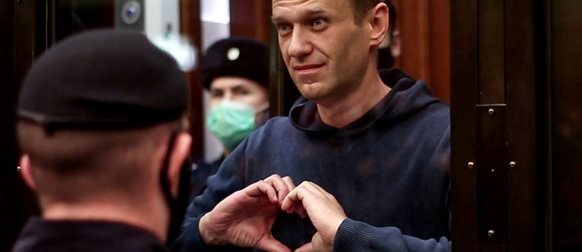 Alexei Navalny faz gesto em formato de coração com as mãos de dentro de uma cela de vidro durante uma audiência em Moscou