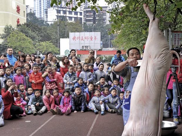 Açougueiro carneou porco em escola na China e chocou crianças (Foto: Reuters)