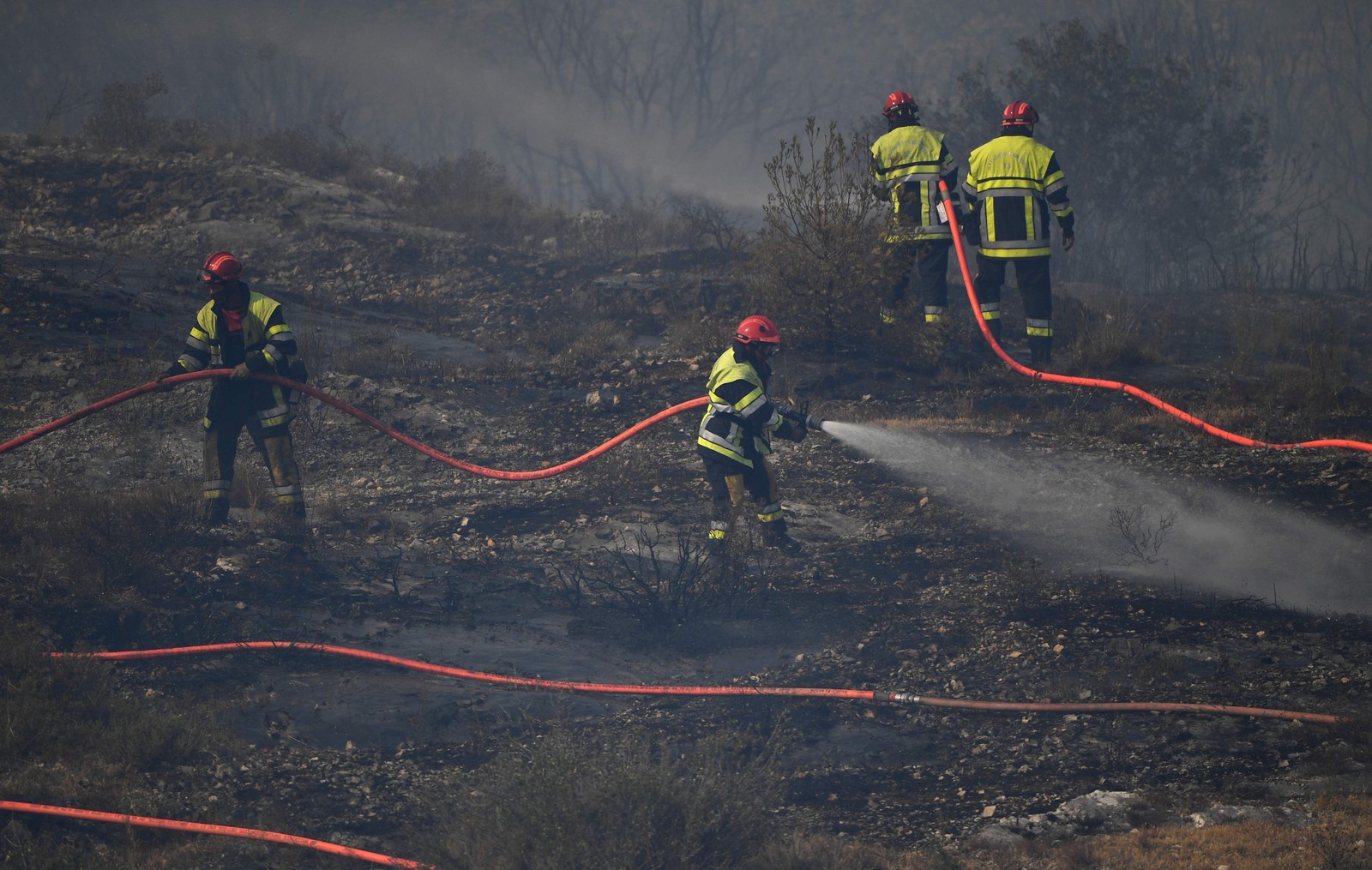 Bombeiros trabalham para apagar um incêndio florestal em Tarascon, sudeste da França — Foto: CLEMENT MAHOUDEAU / AFP