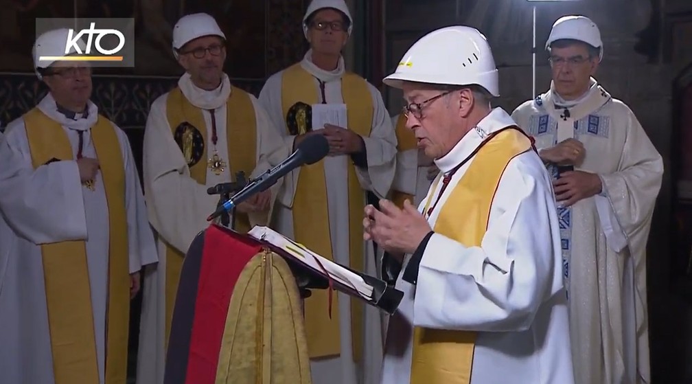 De capacete, padres católicos da Diocese de Paris dividiram as leituras bíblicas durante a primeira missa na Catedral de Notre-Dame após o incêndio de abril — Foto: Reprodução/KTOTV