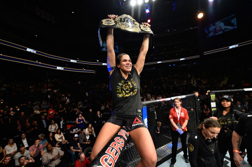 Amanda Nunes comemora sobre o octógono com o cinturão peso-galo no UFC 215 (Foto: Getty Images)
