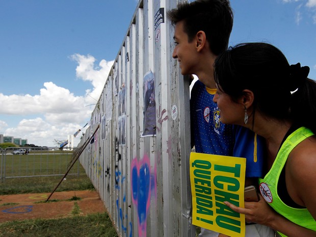 Manifestantes pró impeachment observam o outro lado do muro que divide os dois grupos em Brasília (Foto: Beto Barata/AFP)