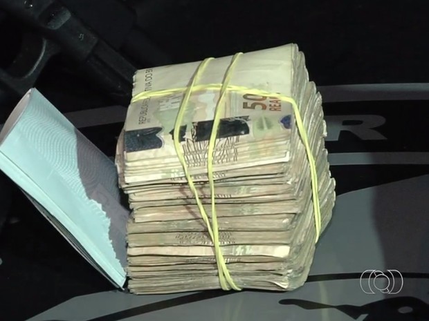 Dinheiro e cheques também foram apreendidos com suspeitos, em Goiás (Foto: Reprodução/TV Anhanguera)