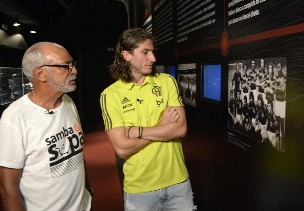 Junior e Filipe Luis observam fotos de times que marcaram época no Flamengo — Foto: André Durão