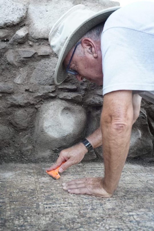 O arqueólogo Mordechai Aviam limpa a inscrição que pode indicar local de nascimento de São Pedro (Foto: Zachary Wong / Centro para o Estudo do Judaísmo Antigo e Origens Cristãs)